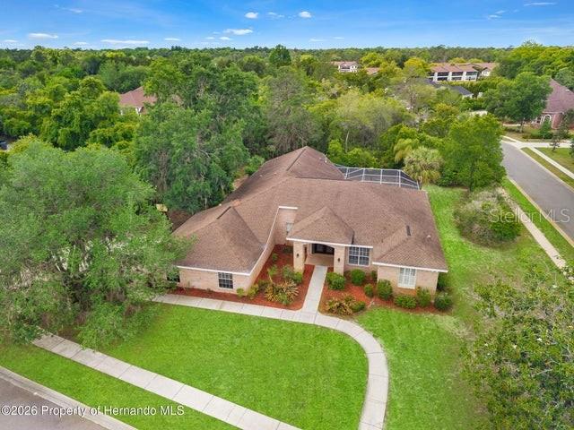 An aerial view shows a single-story house with a brown roof and a front lawn — 6153 NEW OSPREY POINT, WEEKI WACHEE, FL