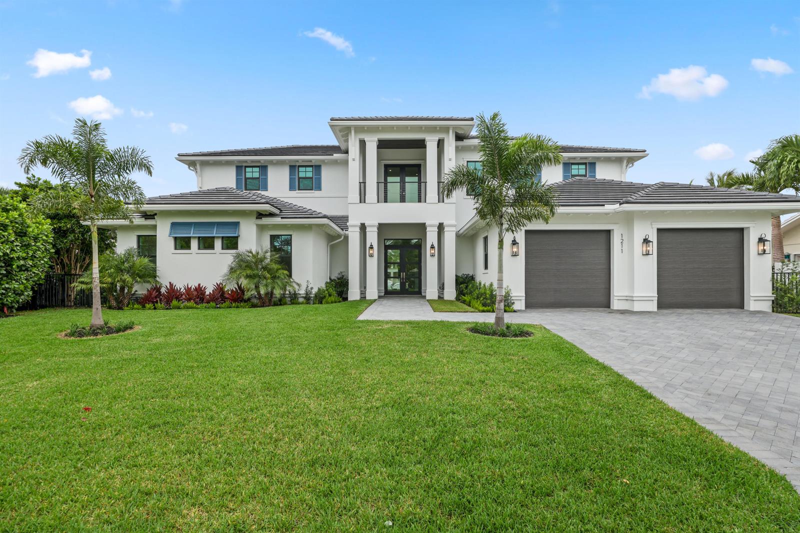 A two-story white house with a gray tile roof, two garage doors, and palm trees — 1211 Gulfstream Way, Singer Island FL 33404, SINGER ISLAND, FL