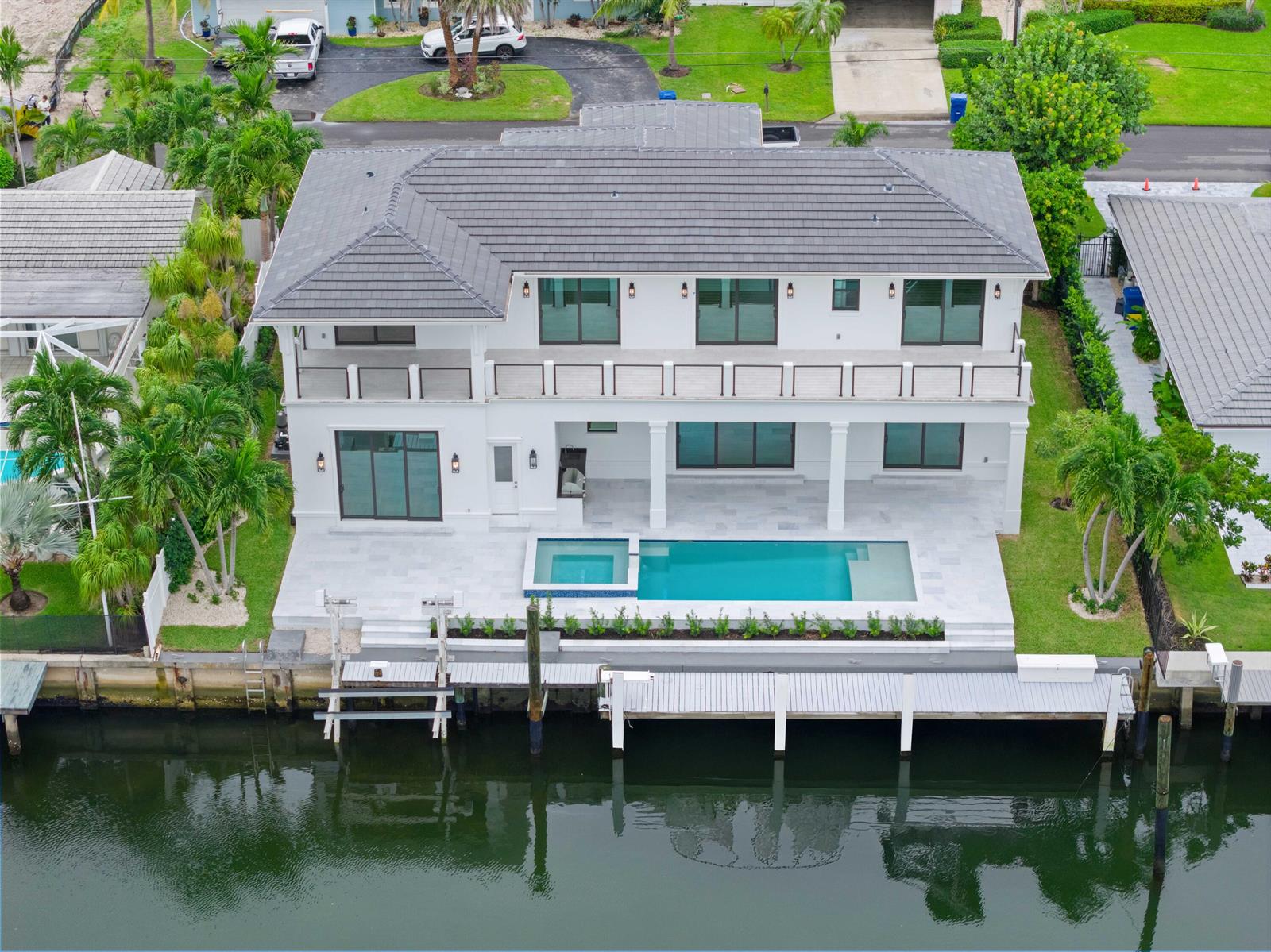 An aerial view of a two-story white house with a pool, deck, and private dock — 1211 Gulfstream Way, Singer Island FL 33404, SINGER ISLAND, FL