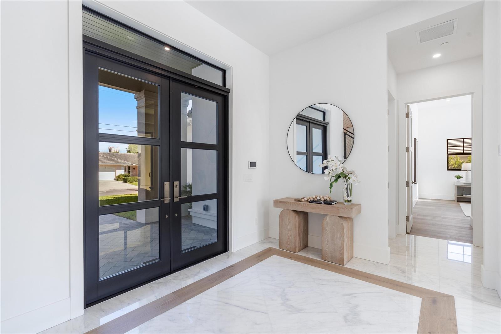 A bright entryway features a black double door, marble flooring with wood inlay, and a console — 1211 Gulfstream Way, Singer Island FL 33404, SINGER ISLAND, FL