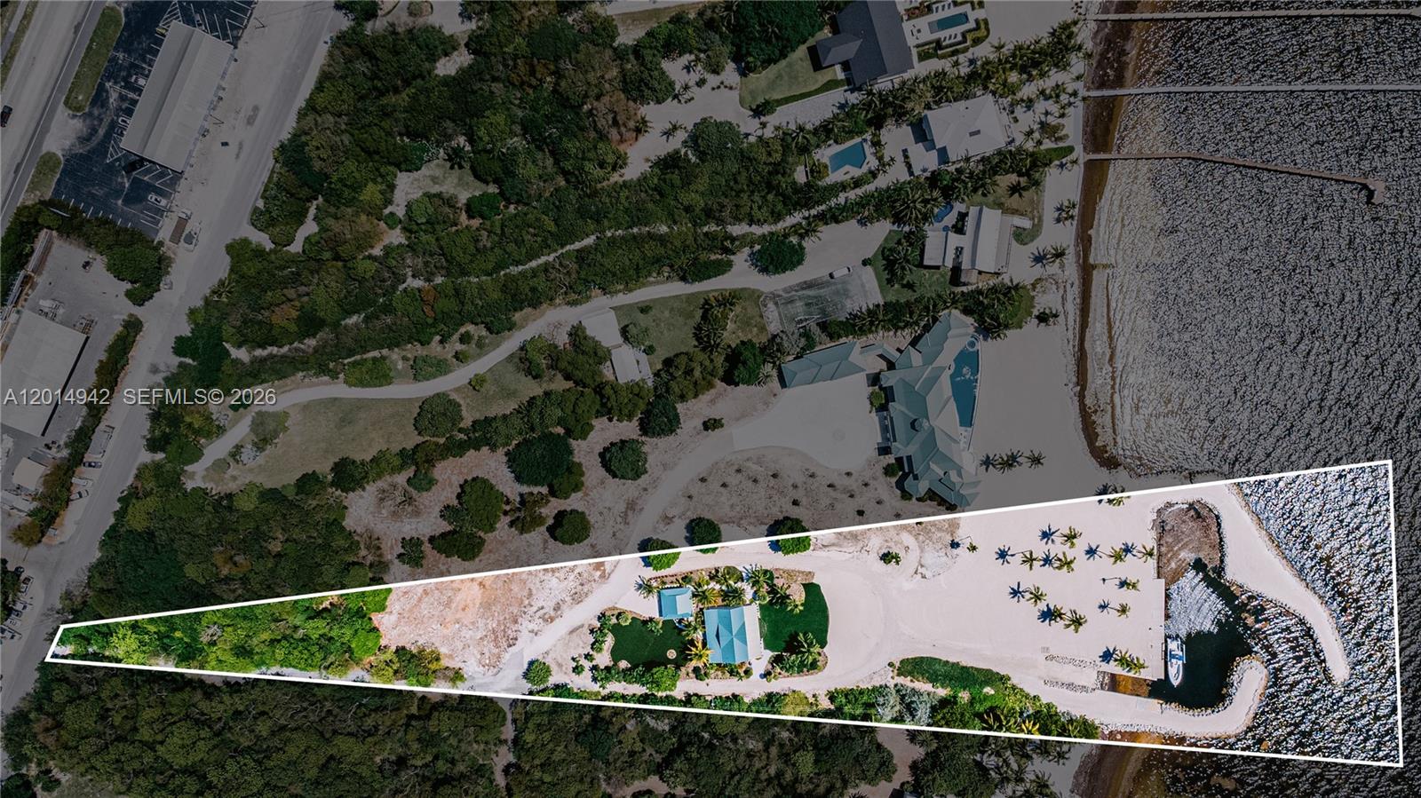 This aerial view shows a waterfront property with a house, sandy beach, and boat slip — 88835 Old Hwy, Tavernier FL 33070, TAVERNIER, FL