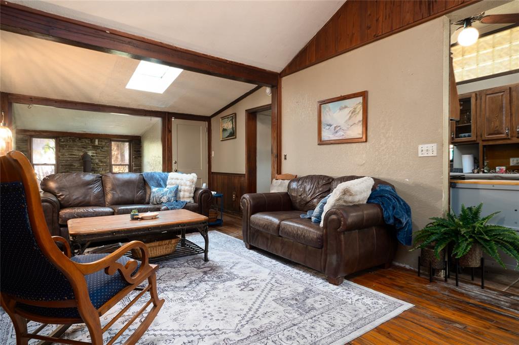 A living room features leather sofas, a wooden rocking chair, and a patterned area rug — 5560 PARK AVENUE, DE LEON SPRINGS, FL