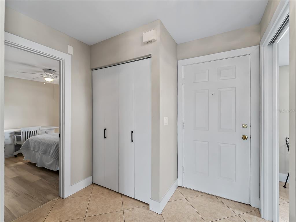 An entryway features tile flooring, a white closet, and a doorway leading into a bedroom — 4668 OAK HILL LANE UNIT 40, SARASOTA, FL