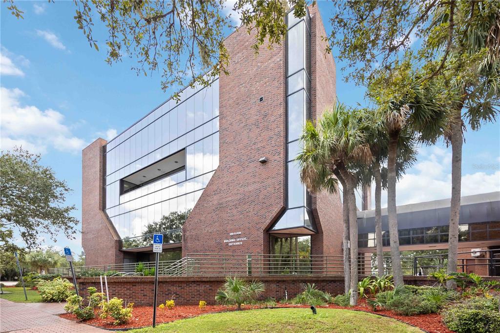 A multi-story brick and glass office building features a landscaped front yard with palm trees — 1620 TAMIAMI TRAIL, PORT CHARLOTTE, FL