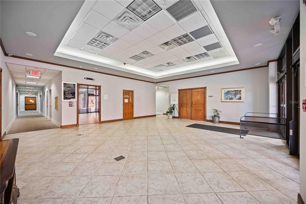 A spacious commercial lobby features a tiled floor, recessed ceiling lighting, and wooden double doors — 1620 TAMIAMI TRAIL, PORT CHARLOTTE, FL
