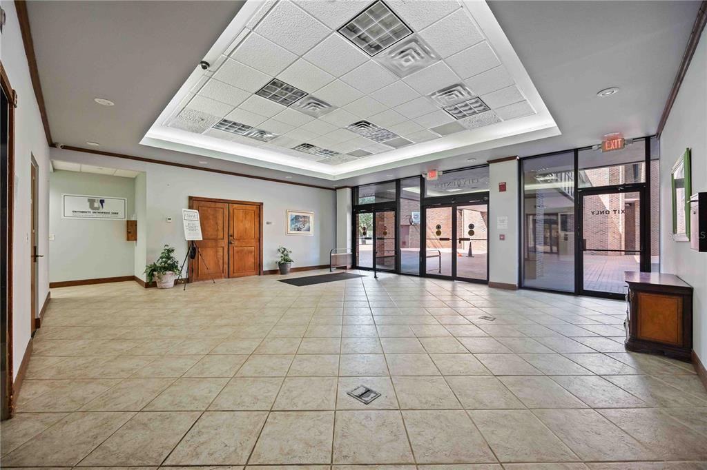 A spacious commercial lobby features beige tile flooring, a recessed drop ceiling, and glass entrance doors — 1620 TAMIAMI TRAIL, PORT CHARLOTTE, FL