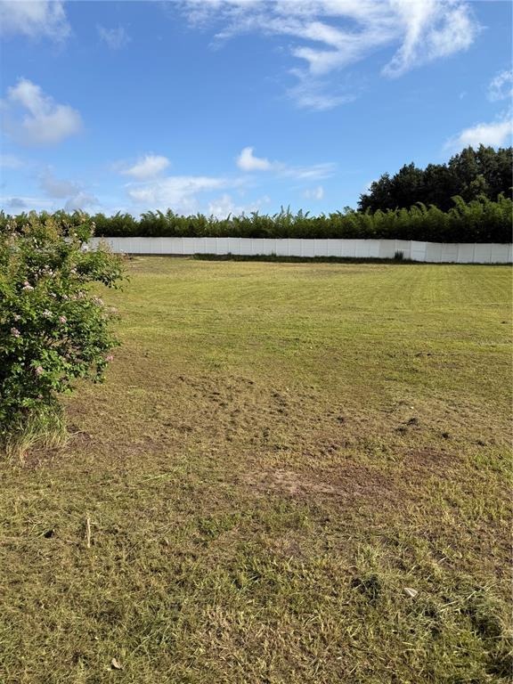 A large, flat, grassy lot is enclosed by a white fence and a tree line — 0 NORTH BLVD W, DAVENPORT, FL
