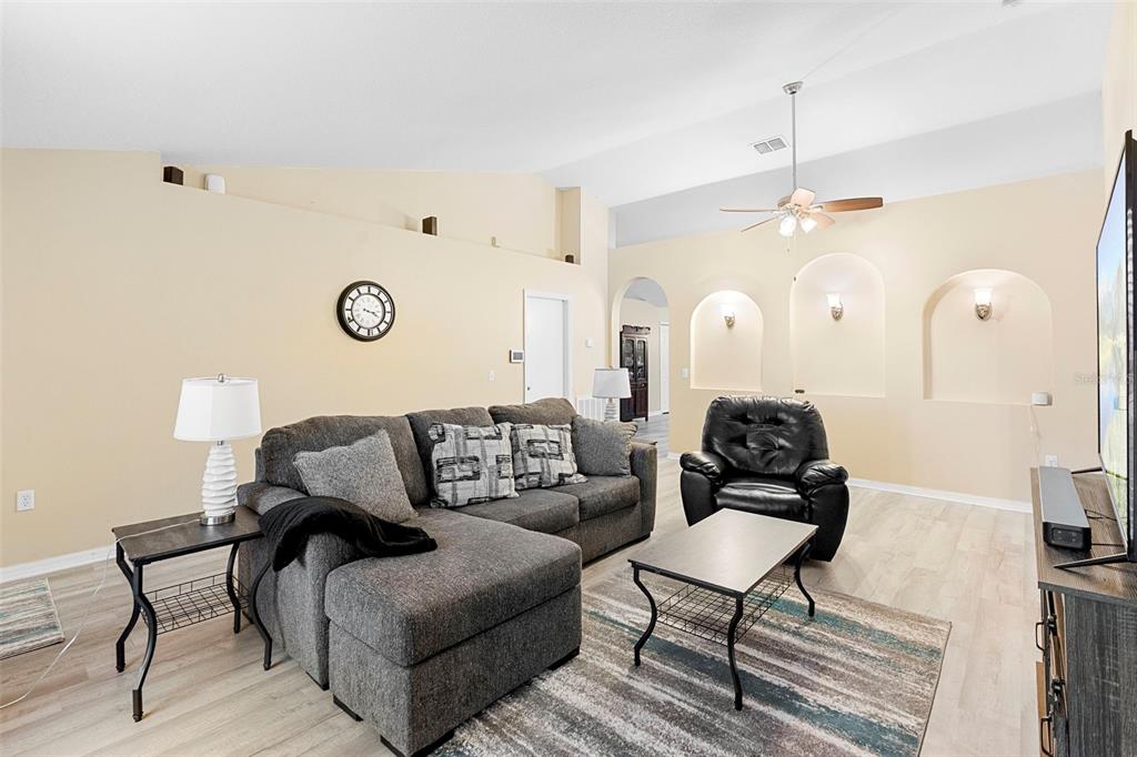 A living room features a gray sectional sofa, a black recliner, and three arched wall niches — 3750 SW 127TH LANE ROAD, OCALA, FL