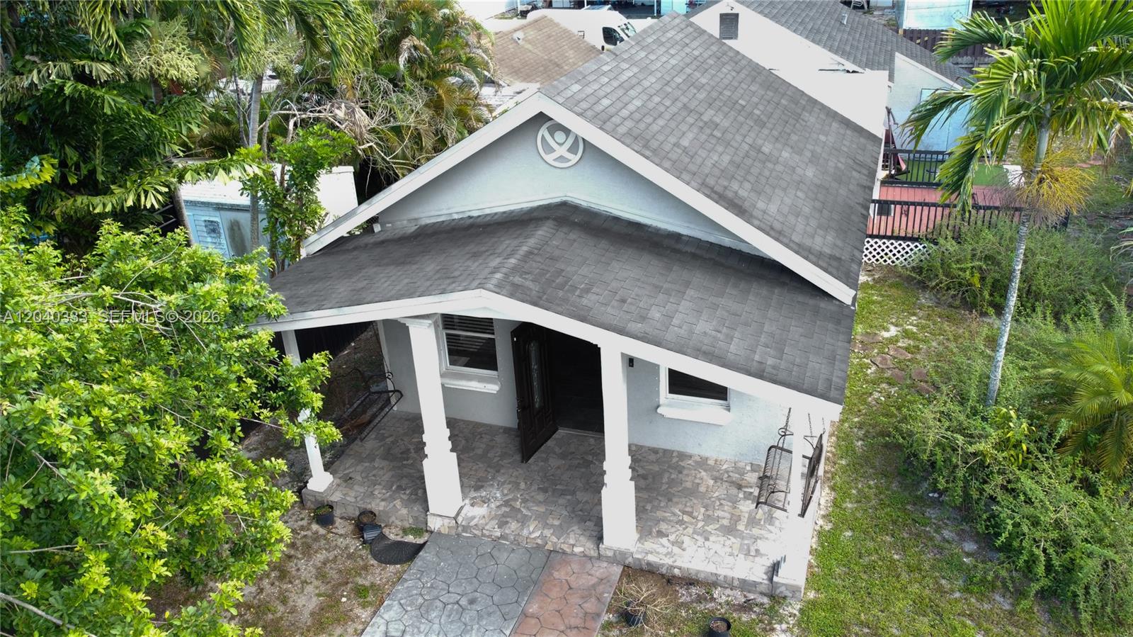 An aerial view of a small house with a covered front porch and shingled roof — 2218 Harding St, Hollywood FL 33020, HOLLYWOOD, FL