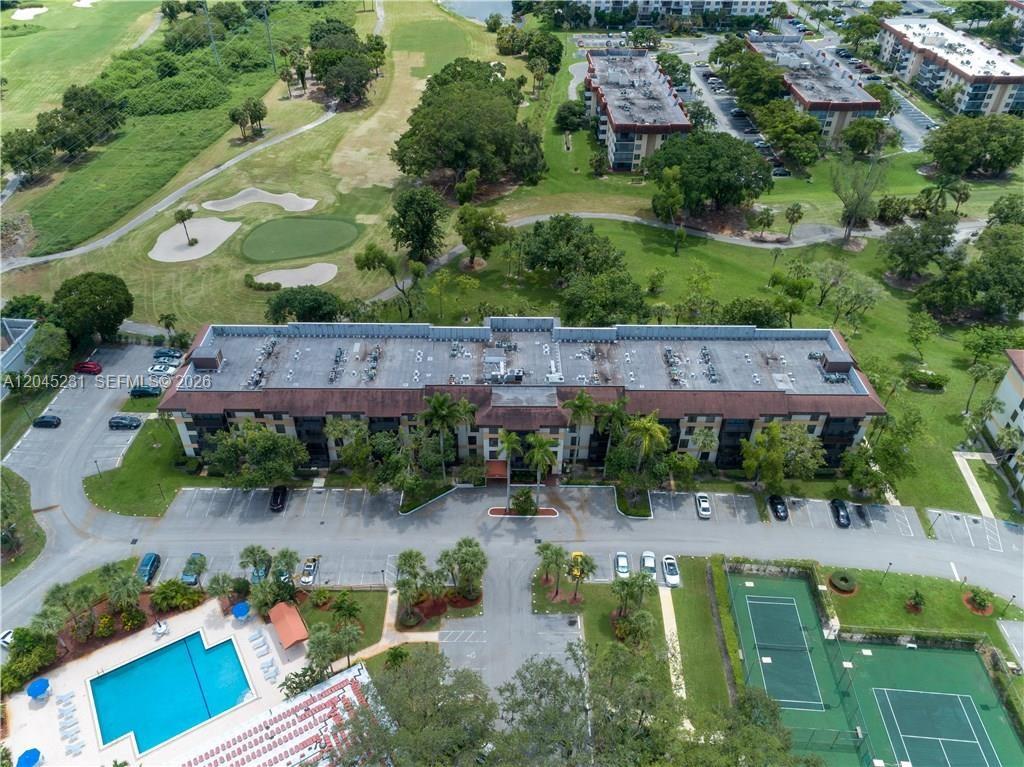 An aerial view shows a multi-story apartment building with a pool and tennis courts nearby — 5530 NW 44th St # 408C, Lauderhill FL 33319, LAUDERHILL, FL