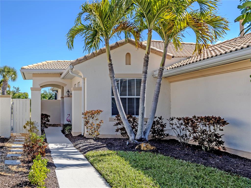 A single-story house exterior features a palm tree, a walkway, and a small lawn — 254 MESTRE PLACE, NORTH VENICE, FL