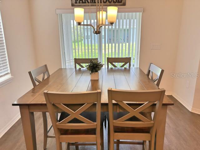A dining area features a wooden table with four chairs and a modern light fixture — 737 DAPHNE DRIVE, POLK CITY, FL