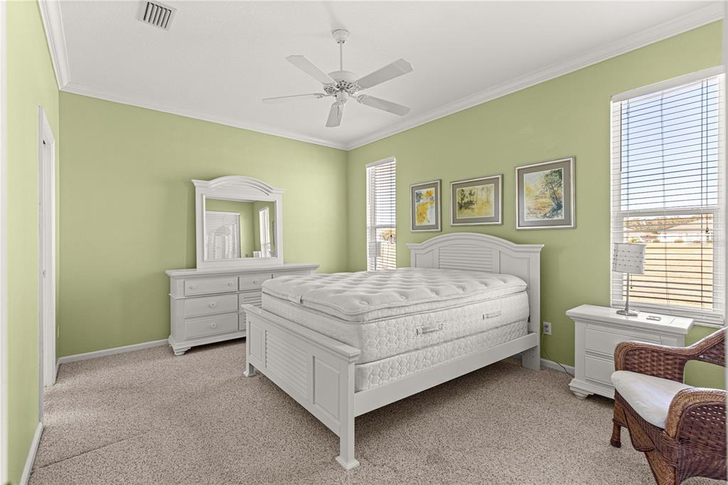 A bedroom features light green walls, white furniture, a bed with a mattress, and carpeted flooring — 2380 NW 53RD AVENUE ROAD, OCALA, FL