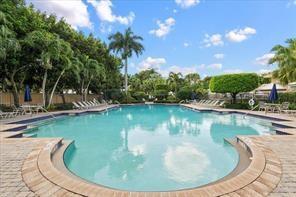 A large outdoor swimming pool surrounded by a brick patio, palm trees, and lounge chairs — 112 Lancaster Way, Royal Palm Beach FL 33414, ROYAL PALM BEACH, FL
