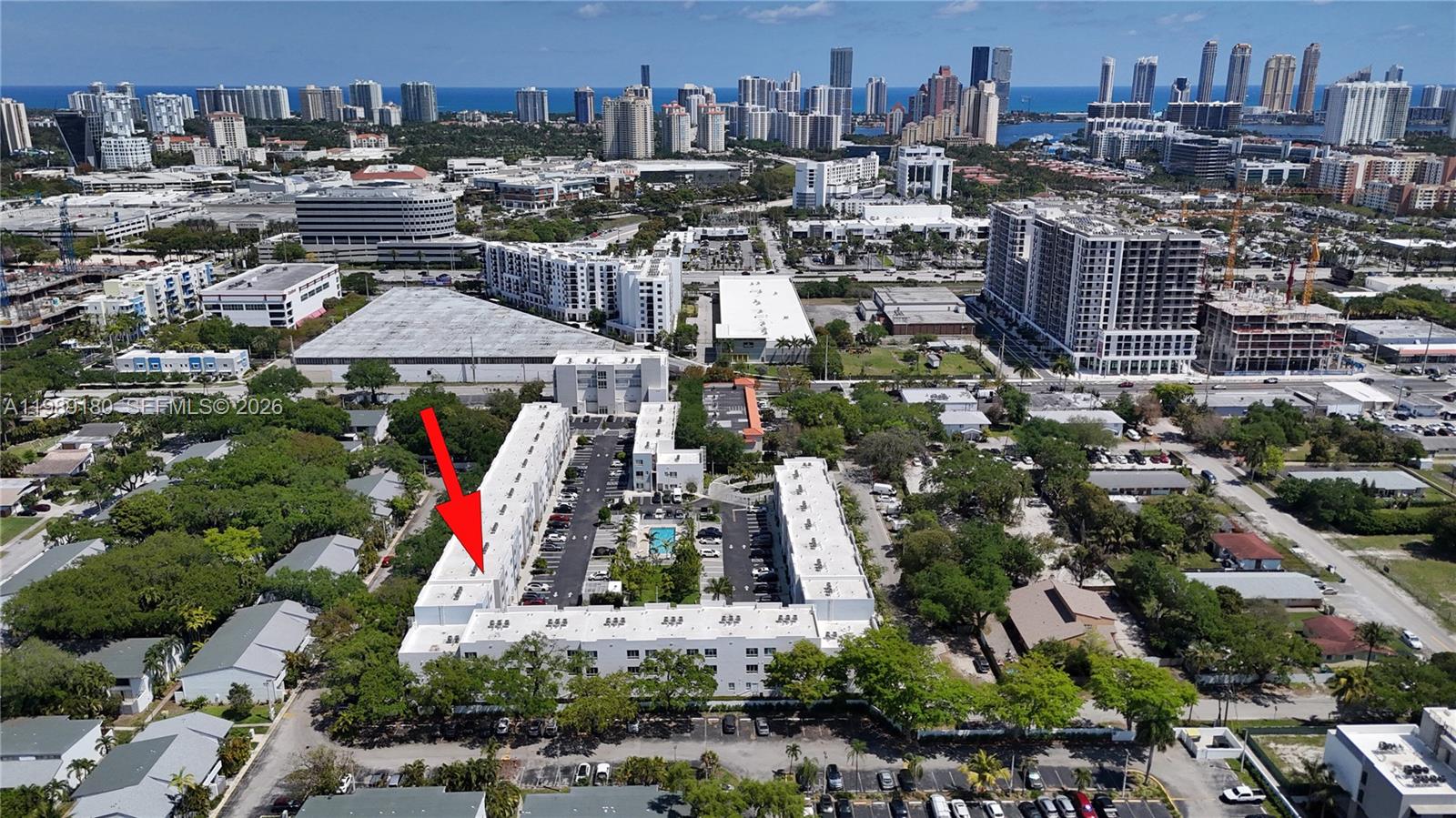 An aerial view shows a multi-story residential complex with a central parking lot and pool — 2555 NE 193rd St # 2122, Miami FL 33180, MIAMI, FL