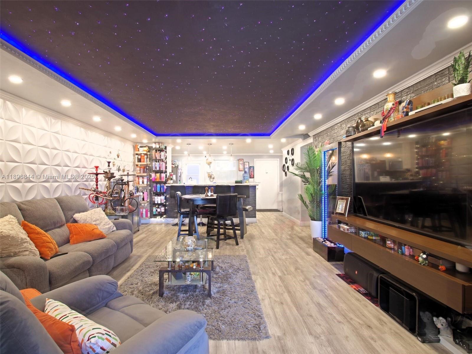 A living room features a star-effect ceiling with blue LED lighting and a textured wall — 420 NE 12th Ave # 401, Hallandale Beach FL 33009, HALLANDALE BEACH, FL