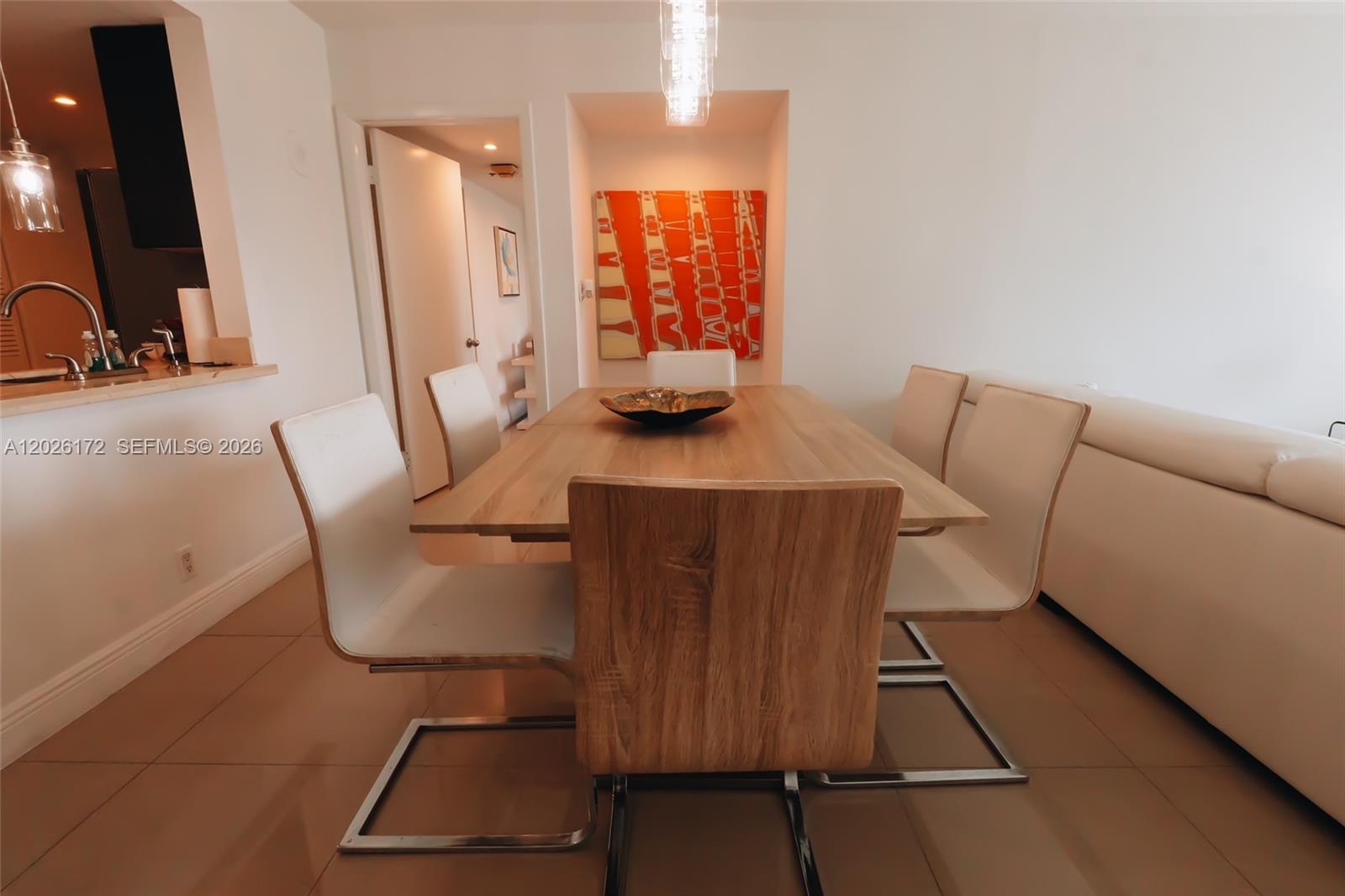 A dining room features a wooden table, six modern chairs, and an abstract orange painting — 1717 N Bayshore Dr # 1253, Miami FL 33132, MIAMI, FL