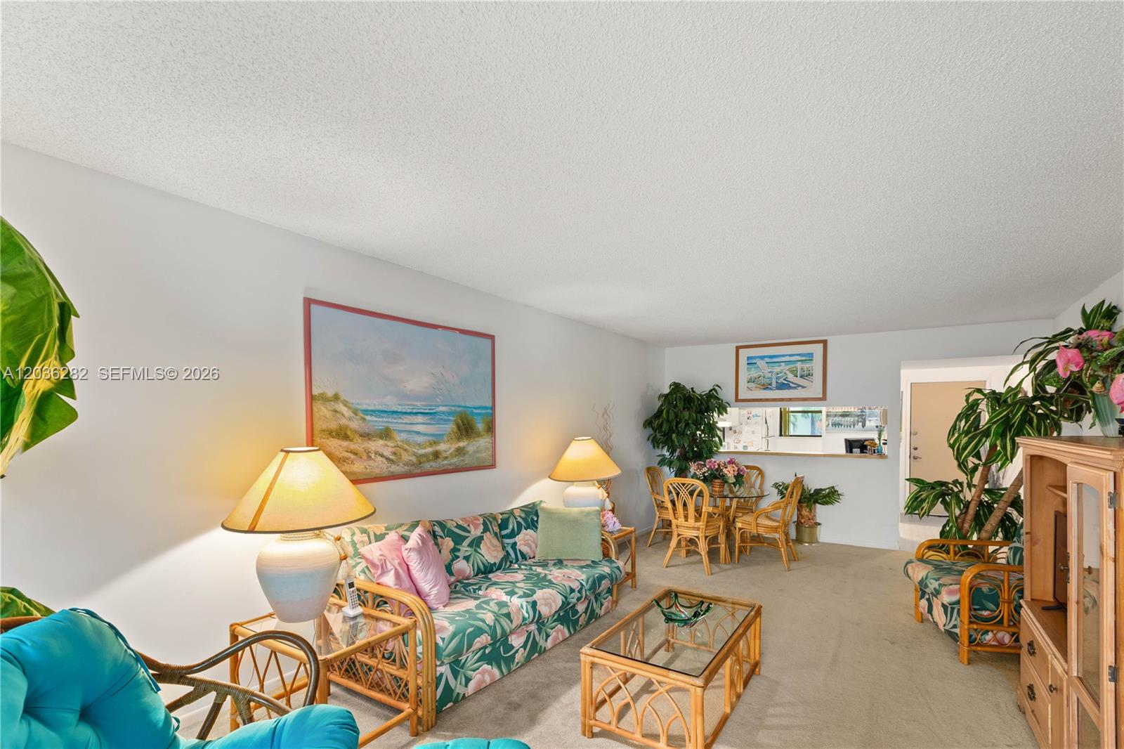 A living room features floral furniture, a glass coffee table, and a dining area — 10155 NW 9th St Cir # 202, Miami FL 33172, MIAMI, FL