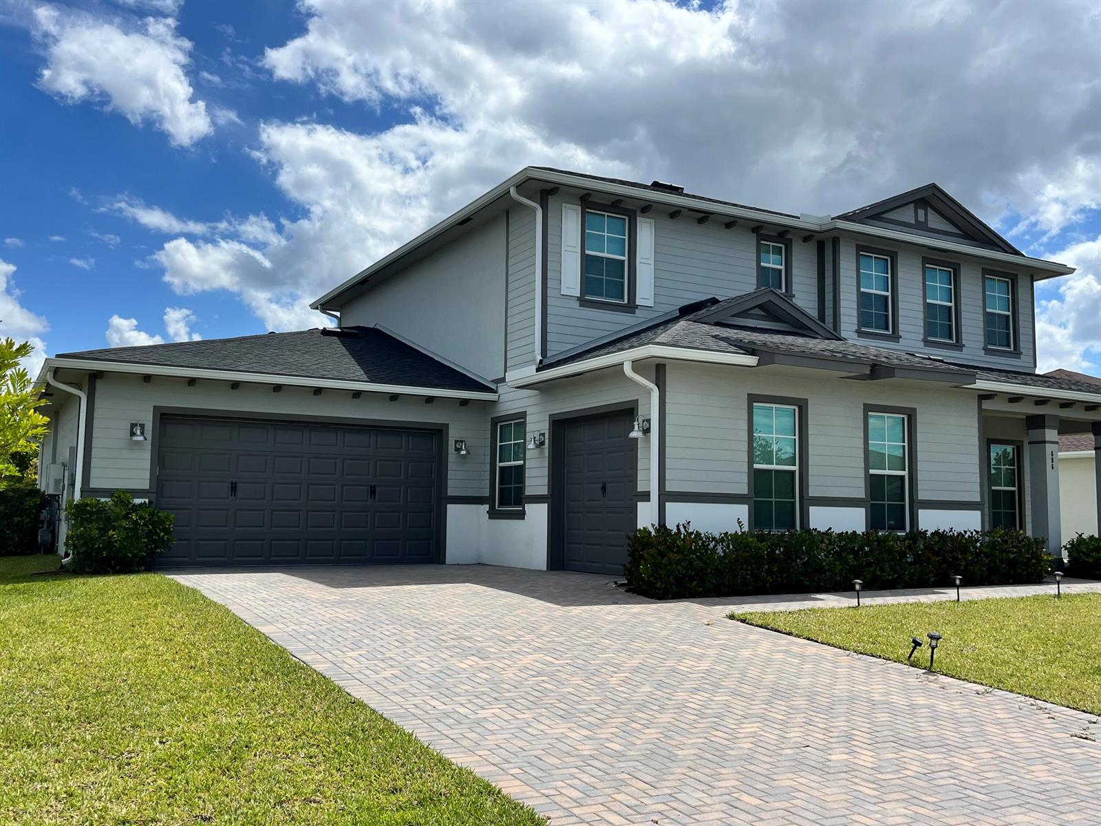 A two-story house with gray horizontal siding, dark trim, and a paved driveway — 686 Hookline Circle, Loxahatchee FL 33470, LOXAHATCHEE, FL