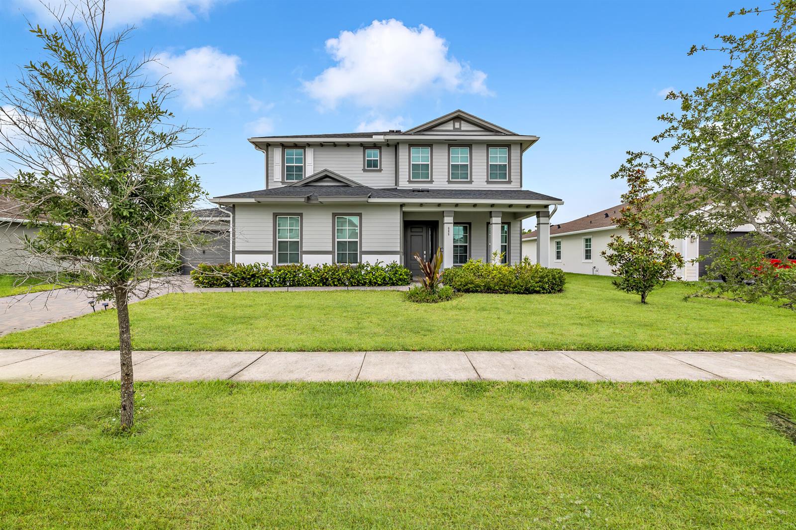 A two-story house with light gray siding, a covered front porch, and a green lawn — 686 Hookline Circle, Loxahatchee FL 33470, LOXAHATCHEE, FL