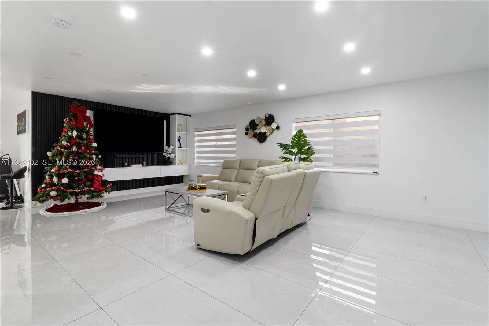 A modern living room features white tile floors, a black accent wall, and a Christmas tree — 14052 SW 167th Ter, Miami FL 33177, MIAMI, FL
