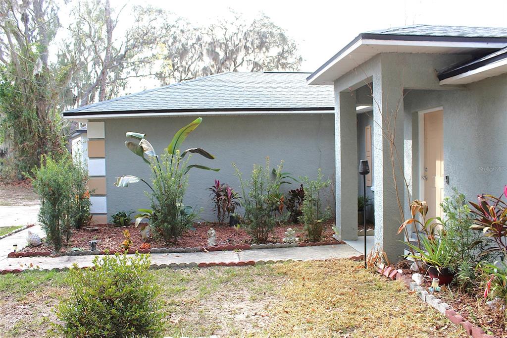 The exterior of a house features a concrete walkway, landscaping, and a covered entryway — 42 DOGWOOD DRIVE COURSE, OCALA, FL