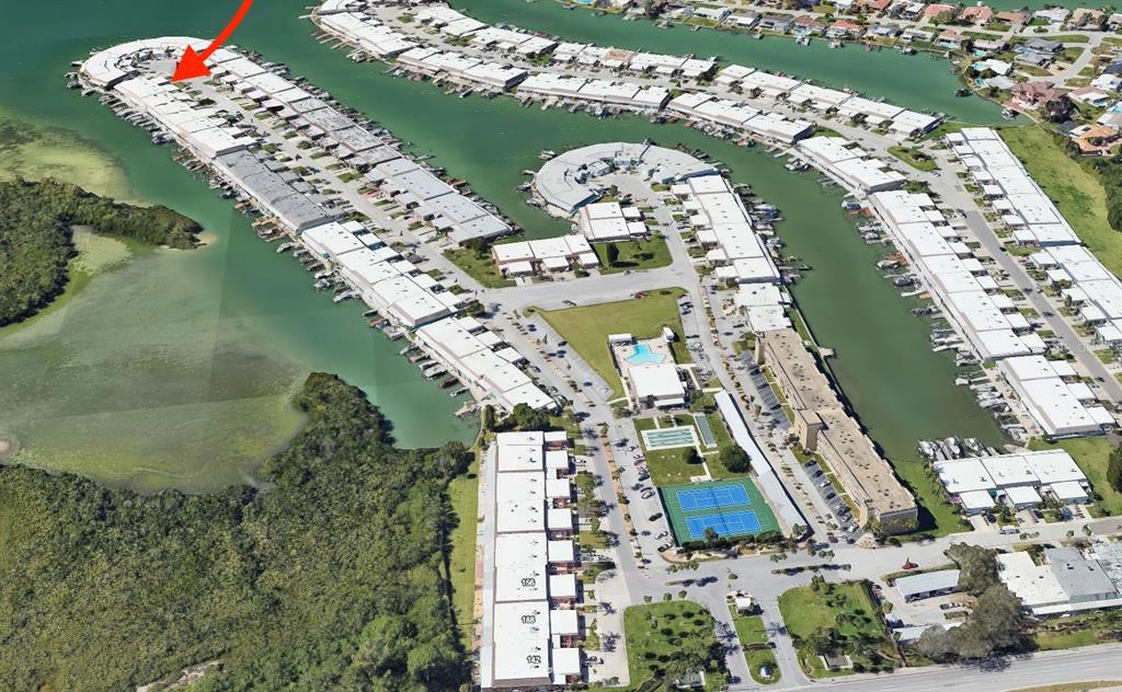 An aerial view shows a waterfront residential complex with boat slips and tennis courts — 636 BOCA CIEGA POINT BOULEVARD S, ST PETERSBURG, FL