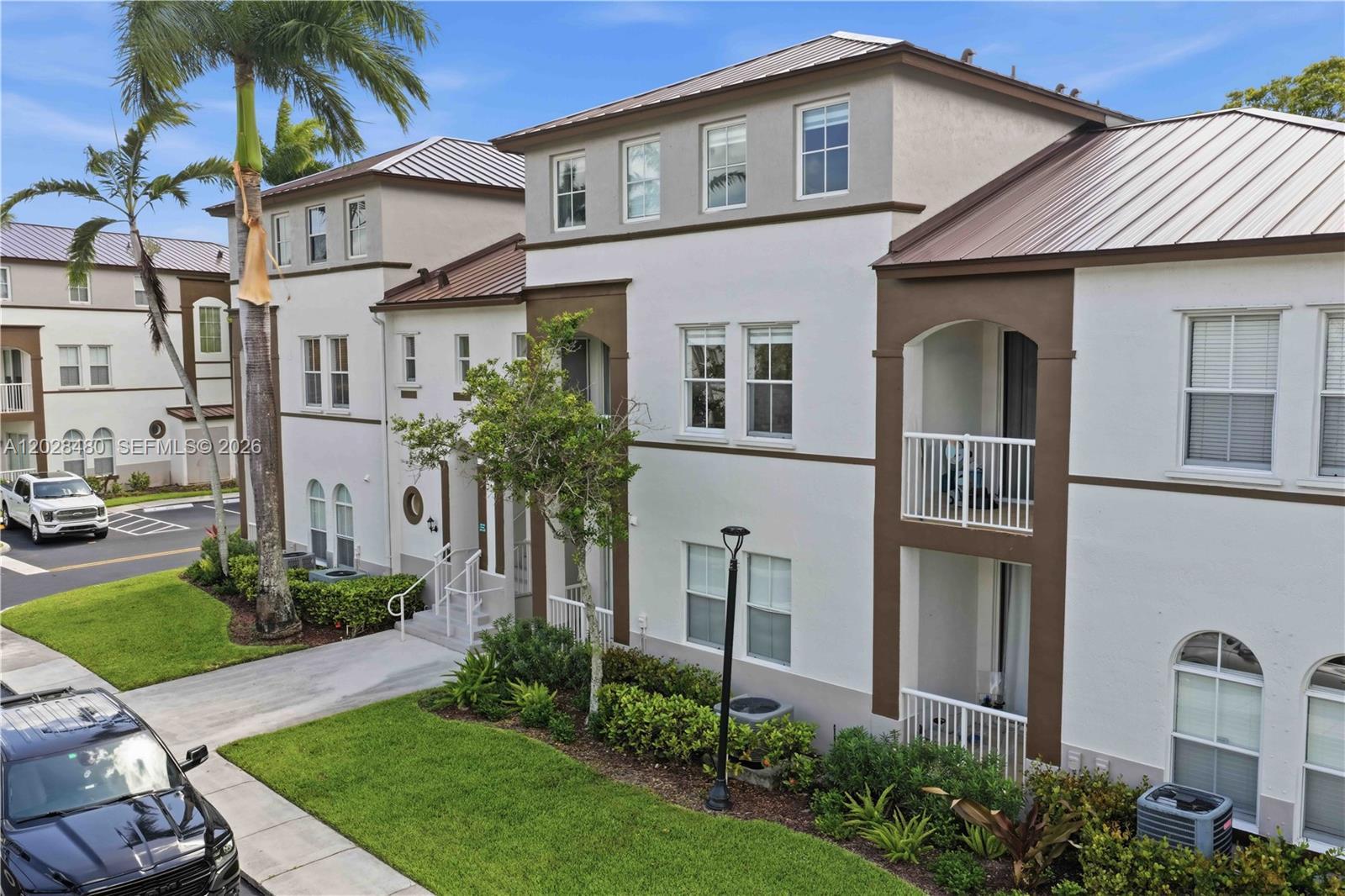 A three-story residential building with white stucco walls, brown trim, and metal roofing — 4425 SW 160th Ave # 213, Miramar FL 33027, MIRAMAR, FL