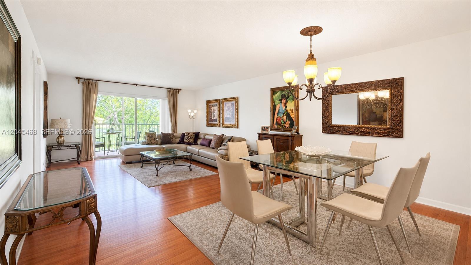 A living and dining room features hardwood floors, a glass dining table, and a sectional — 1151 SW 128th Ter # 206D, Pembroke Pines FL 33027, PEMBROKE PINES, FL