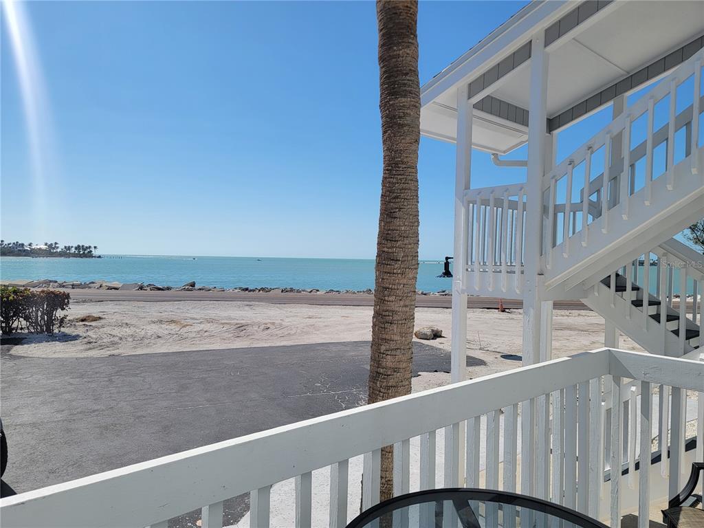 A view of the ocean and beach from a white balcony with a palm tree — 6040 BOCA GRANDE CAUSEWAY UNIT A2, BOCA GRANDE, FL