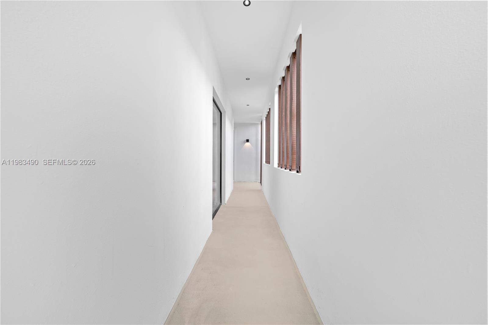 A narrow, white-walled hallway features recessed ceiling lights and a series of wooden-slatted windows — 3187 SW 23rd St, Miami FL 33145, MIAMI, FL