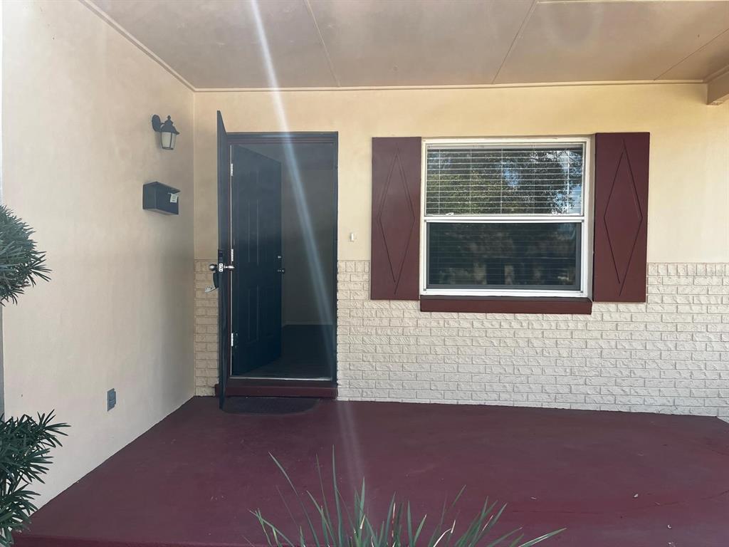 A front porch features a dark red floor, a black door, and a window with shutters — 4810 LEPRECHAUN WAY, ORLANDO, FL