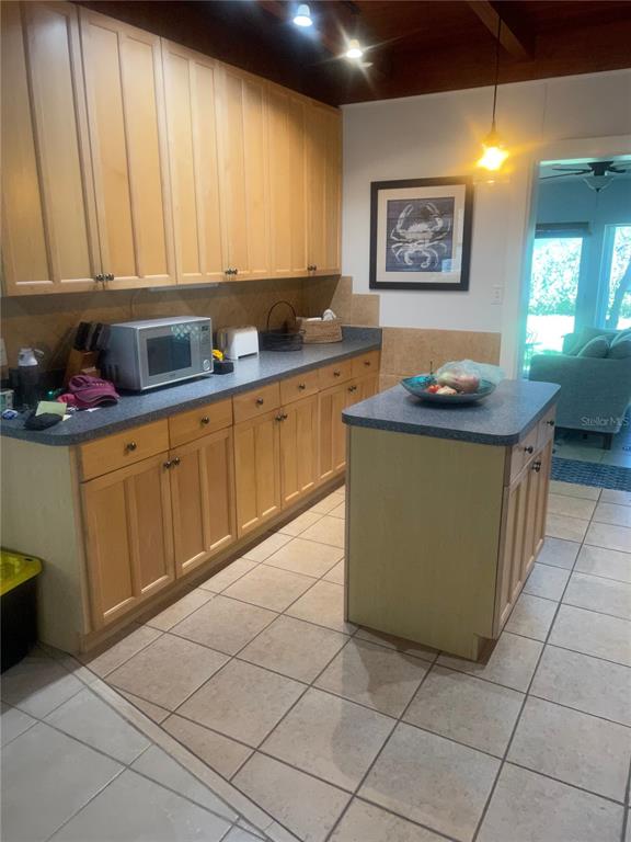 A kitchen with light wood cabinets, a gray countertop, a center island, and tiled floors — 428 COURT STREET, ENGLEWOOD, FL
