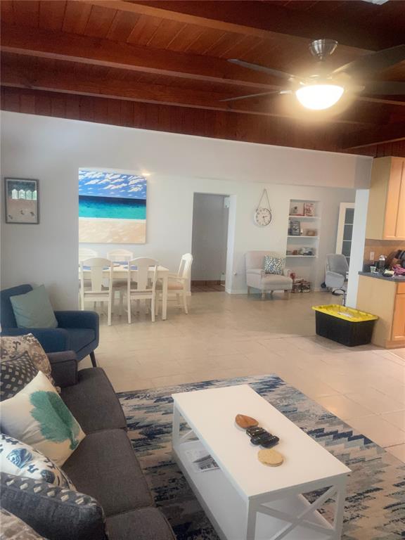 A living room with a white coffee table, gray sofa, and dining area beyond — 428 COURT STREET, ENGLEWOOD, FL