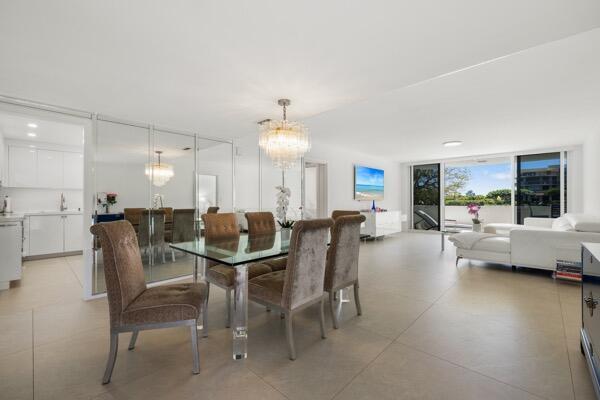 A dining area with a glass table and mirrored wall opens into a bright living room — 2773 S Ocean Boulevard # 214, Palm Beach FL 33480, PALM BEACH, FL