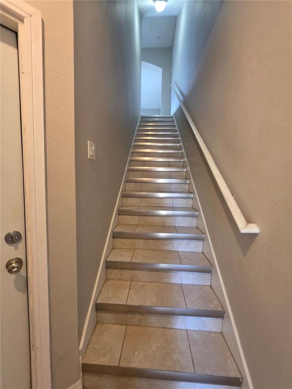 A staircase with tiled steps and a white handrail leads to an upper landing — 810 CALLISTA CAY LOOP, TARPON SPRINGS, FL