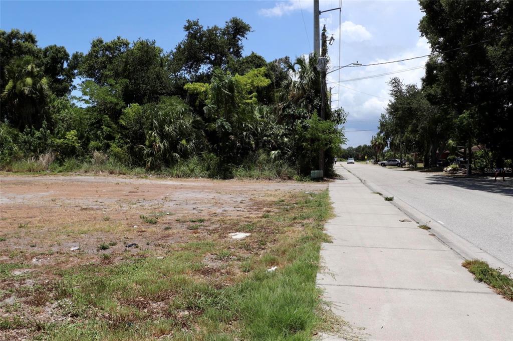 A vacant, grassy lot sits beside a concrete sidewalk and a paved road — 0 MANGO AVENUE, SARASOTA, FL