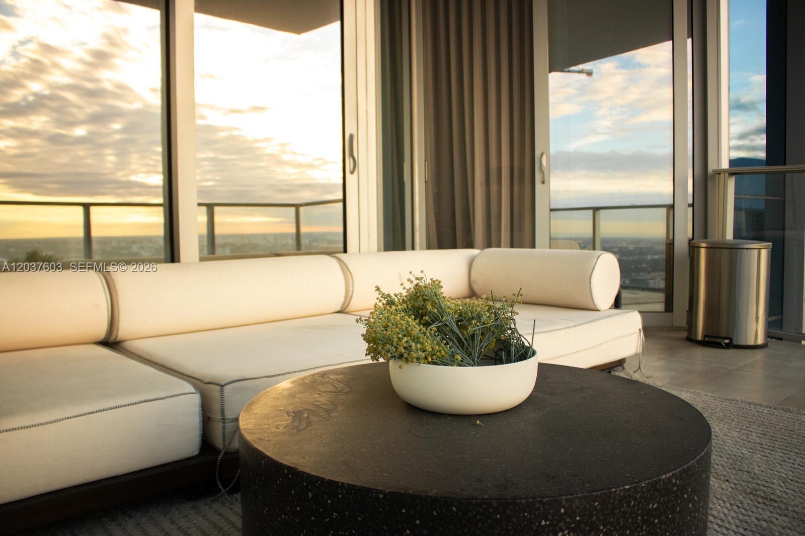 A modern living room features a white sectional sofa, a round dark table, and floor-to-ceiling windows — 851 NE 1st Ave # 4806, Miami FL 33132, MIAMI, FL