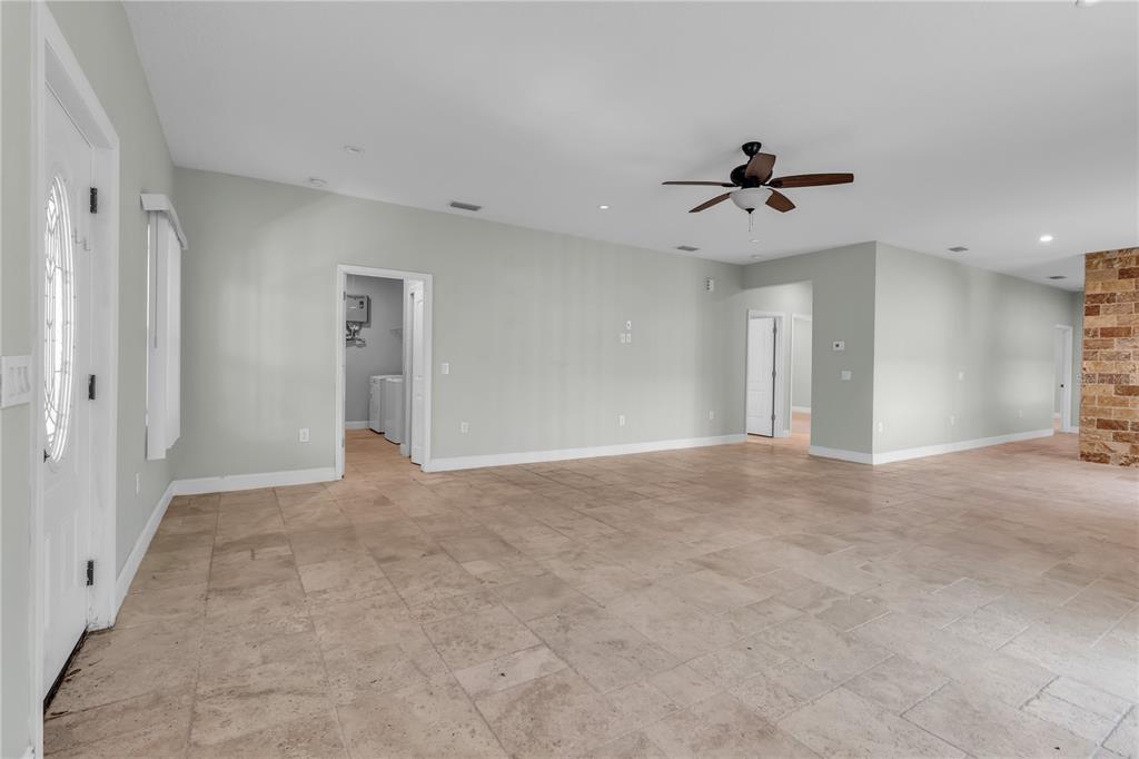 An open-concept living area features light-colored walls, large floor tiles, and a ceiling fan — 1536 25TH STREET, SARASOTA, FL