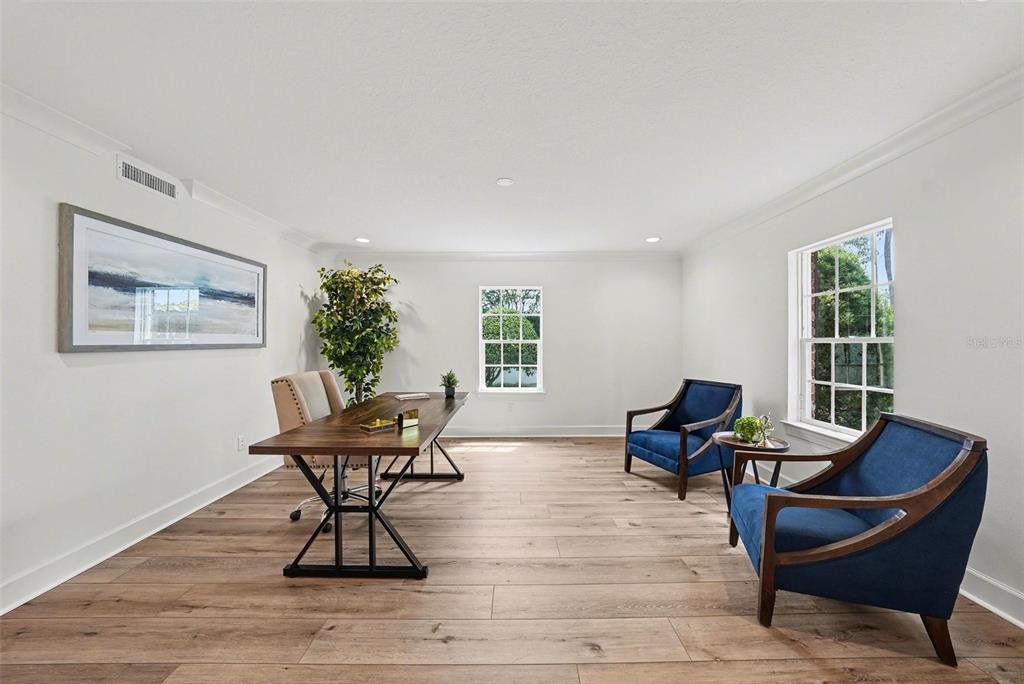 A home office features light wood flooring, a wooden desk, and two blue armchairs — 37403 CHURCH AVENUE, DADE CITY, FL