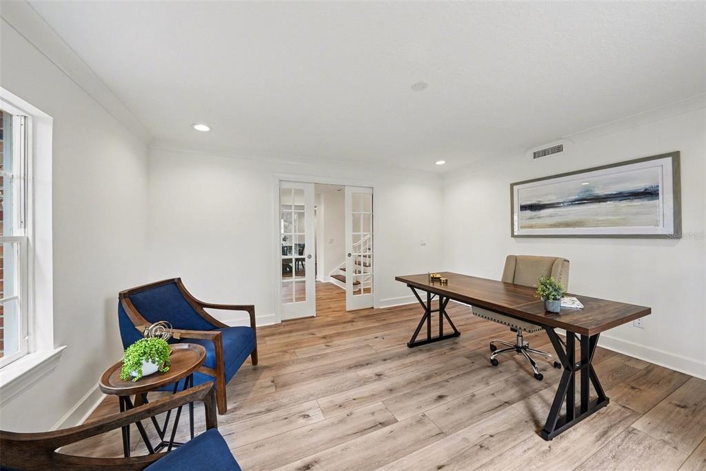 A home office features a wooden desk, two blue armchairs, and light wood flooring — 37403 CHURCH AVENUE, DADE CITY, FL