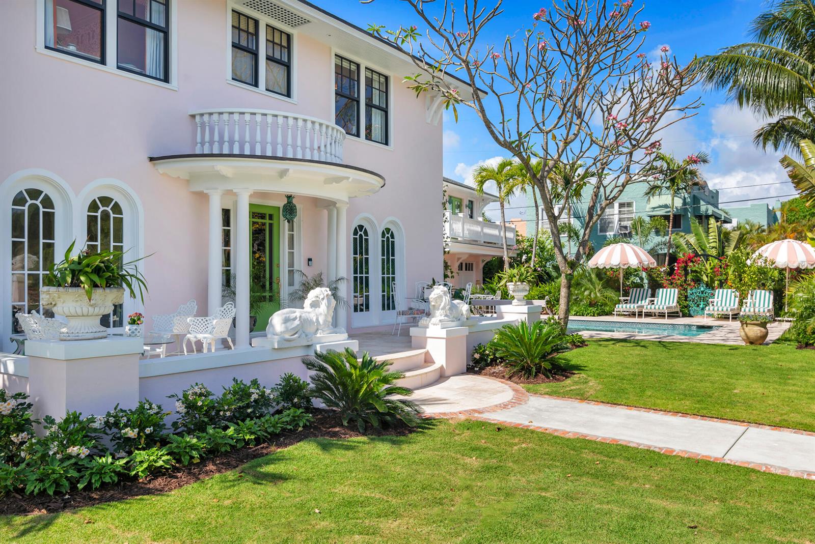 A pink two-story house with a white porch, lion statues, and a backyard swimming pool — 3101 Washington Road, West Palm Beach FL 33405, WEST PALM BEACH, FL