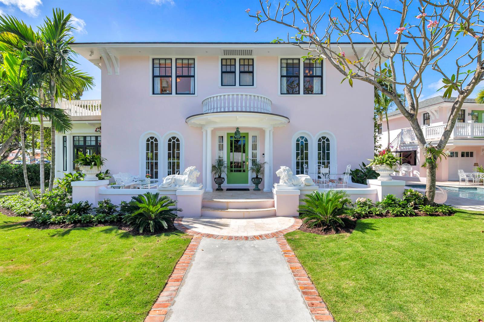 A two-story pink house with a green front door and lion statues on the porch — 3101 Washington Road, West Palm Beach FL 33405, WEST PALM BEACH, FL