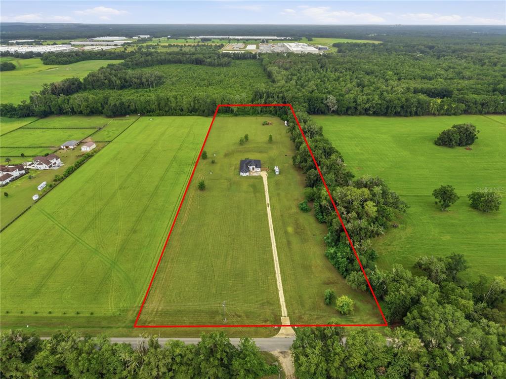 An aerial view shows a house centered on a large, rectangular grassy lot — 18711 NW 138TH AVENUE, ALACHUA, FL