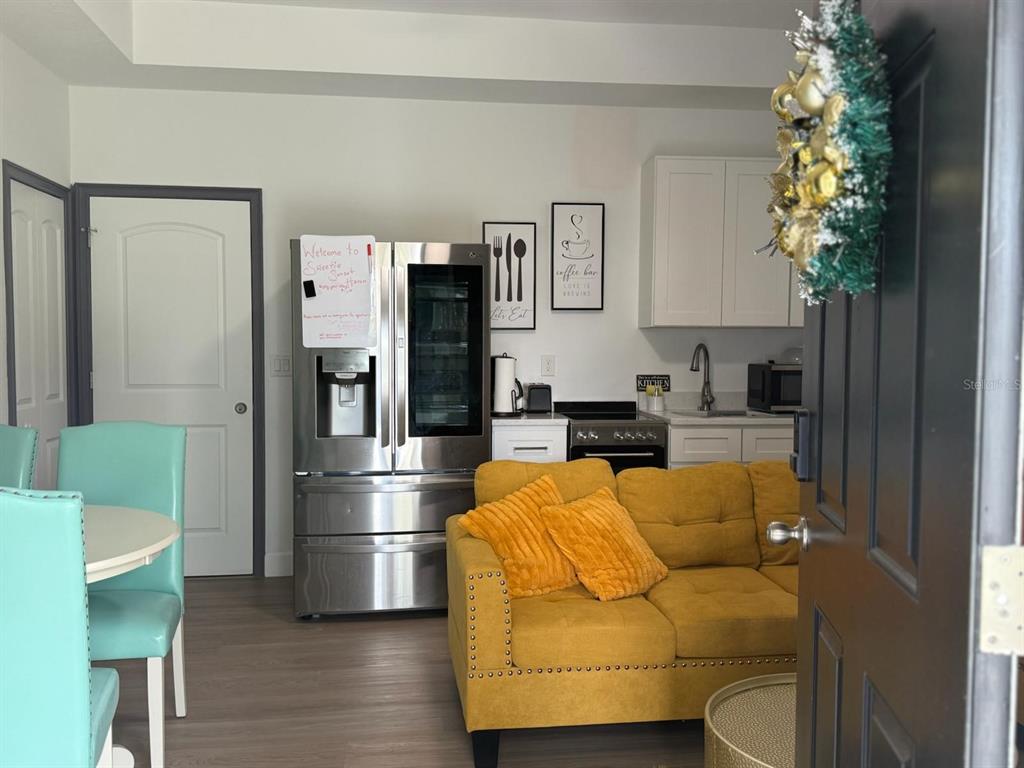 A view from a doorway into a kitchen and living area with a yellow sofa — 2050 FLORIDA DEVELOPMENT ROAD UNIT A, DAVENPORT, FL