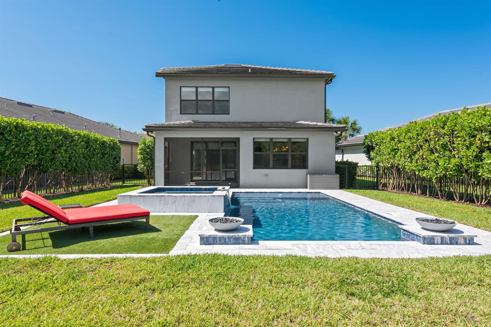 A two-story house features a backyard swimming pool, a hot tub, and a red lounge chair — 4688 E Pinehurst Trl Trail E, Oakland Park FL 33309, OAKLAND PARK, FL