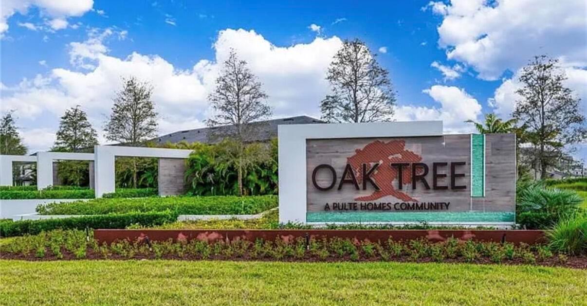 A modern community entrance sign for Oak Tree by Pulte Homes sits in a landscaped lawn — 4688 E Pinehurst Trl Trail E, Oakland Park FL 33309, OAKLAND PARK, FL