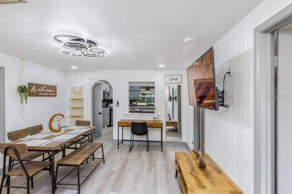A dining area with a wooden table, bench seating, and a desk against the wall — 7524 MARIETTA STREET, ORLANDO, FL