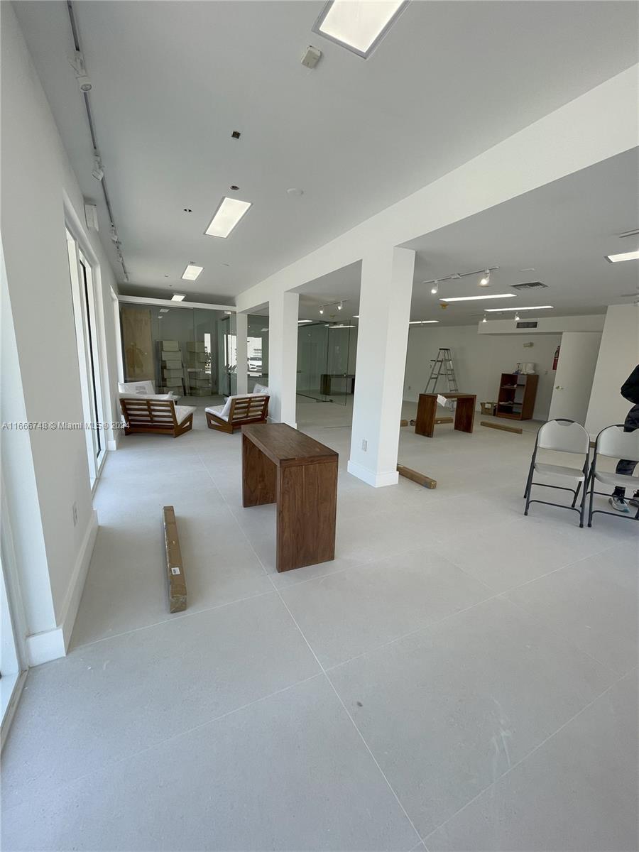 An open-plan commercial space features white walls, light tile flooring, and recessed ceiling lighting — 5050 Biscayne Blvd # 100, Miami FL 33137, MIAMI, FL