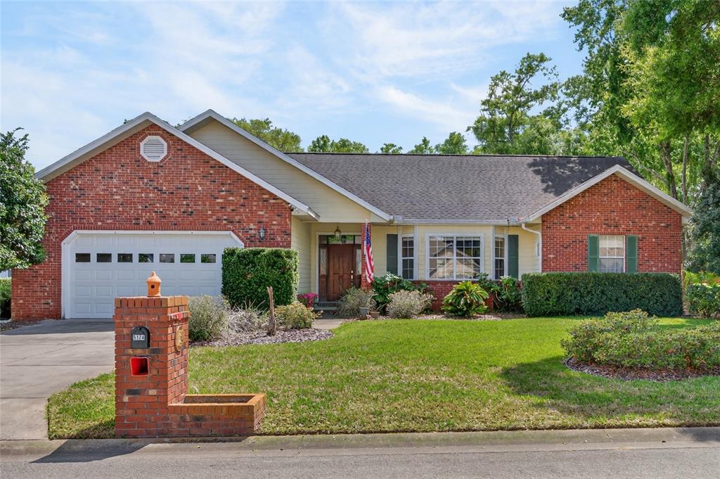 A single-story brick and siding house with a two-car garage and a front lawn — 5174 NE 7TH PLACE, OCALA, FL